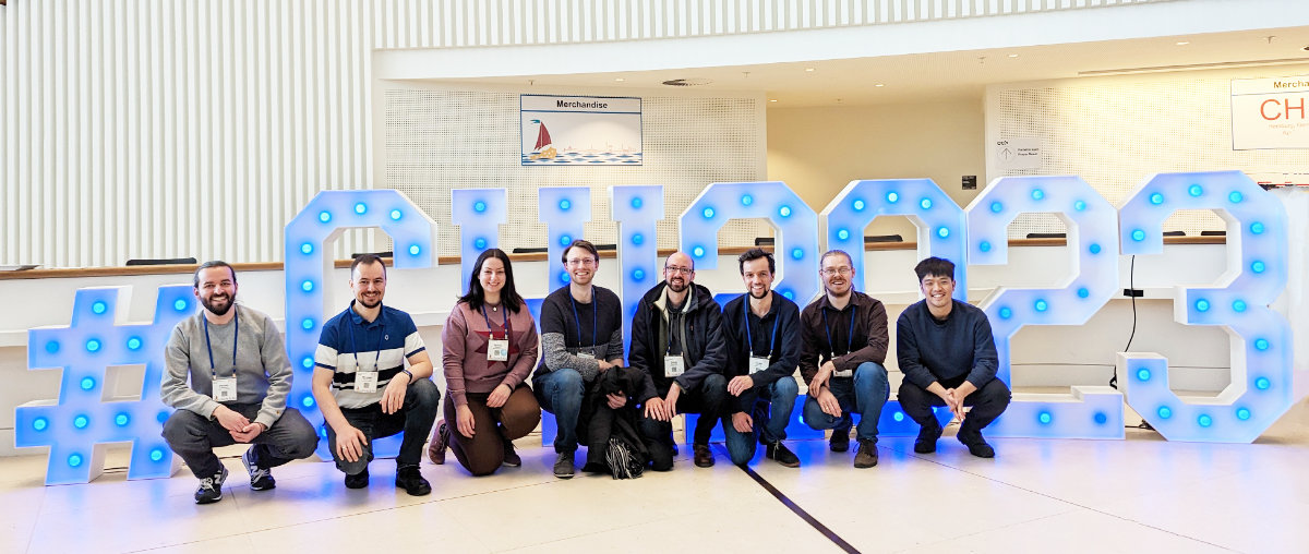 Group picture: UBT team in front of the CHI 2023 sign in the conference entrance hall.