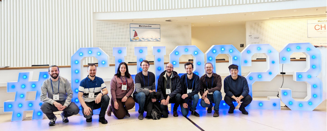 Group picture: UBT team in front of the CHI 2023 sign in the conference hall.