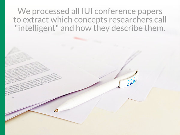Image of a pen and printed papers with caption "We processed all IUI conference papers to extract which concepts researchers call intelligent and how they decribe them."